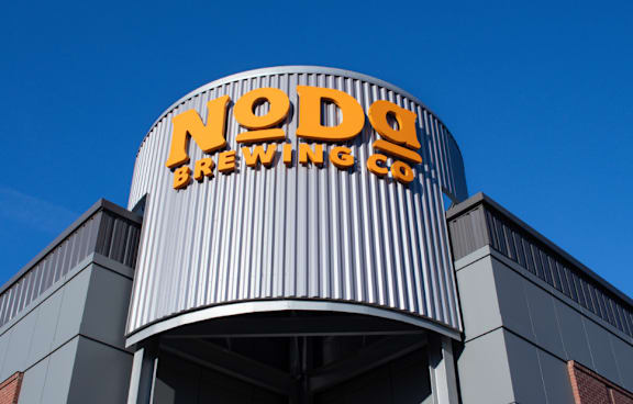 A building with a sign that says "Noda Brewing Co."
