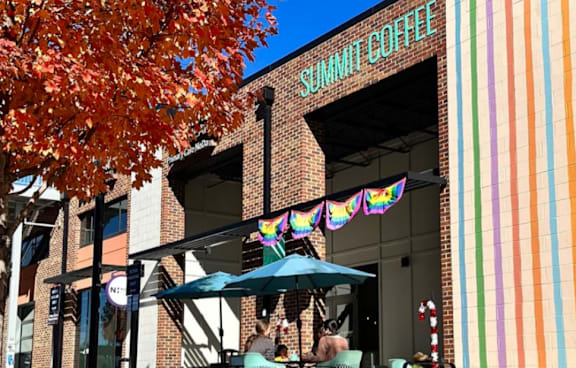 A Summit Coffee shop with a person sitting at a table outside.