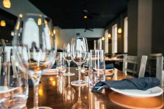 A table set for a meal with wine glasses and a black napkin.