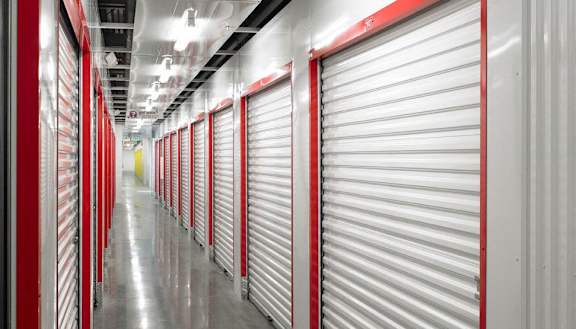 A long hallway with red doors and a yellow square in the distance.