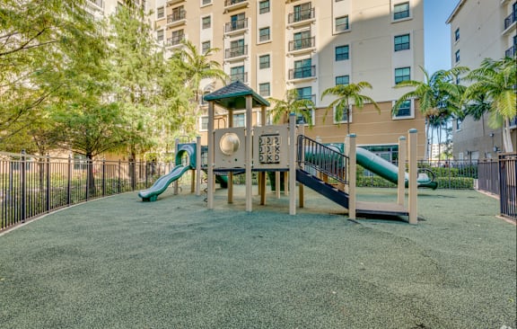 A playground with a green slide and a wooden structure.