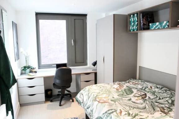 a bedroom with a bed and a desk with a chair