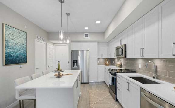 a kitchen with white cabinets and stainless steel appliances