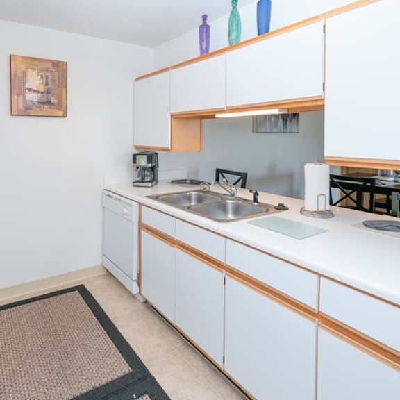 a kitchen with white cabinets and a sink and a refrigerator