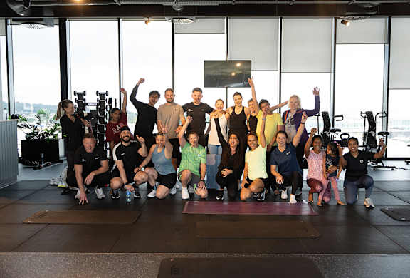 A group of people are gathered in a gym for a photo.