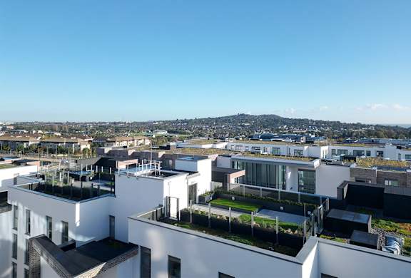 A view of a city from a high vantage point with buildings and greenery.