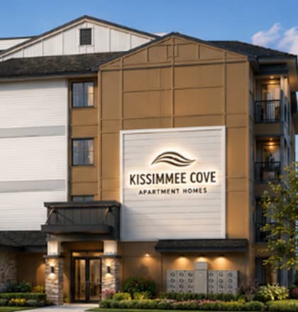 The image shows a modern apartment building named Kissimmee Cove Apartments.