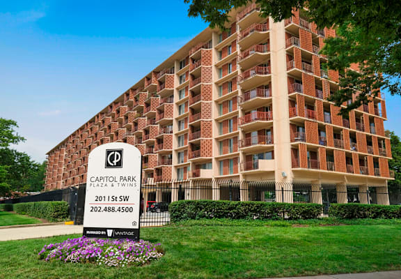 A brick building with a sign in front that says Capitol Park.