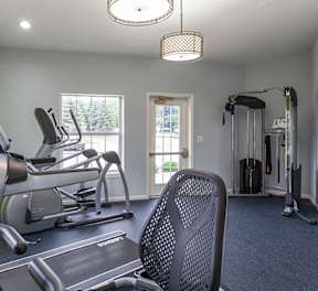 A gym with a green wall that says "work hard and be proud of what you achieve".