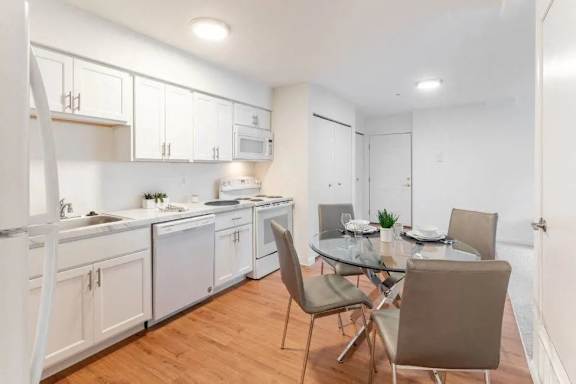 A modern kitchen with a dining table set for four.
