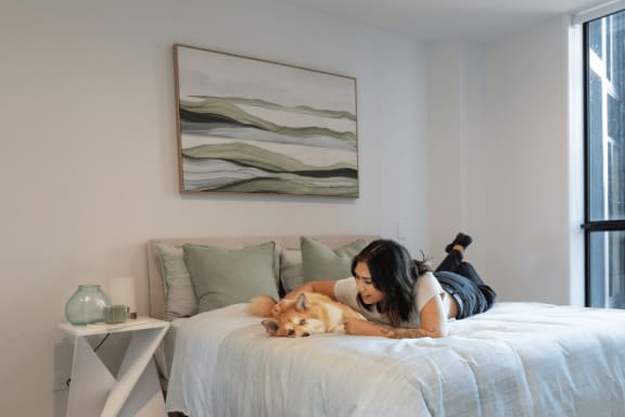 a woman laying on a bed with her dog