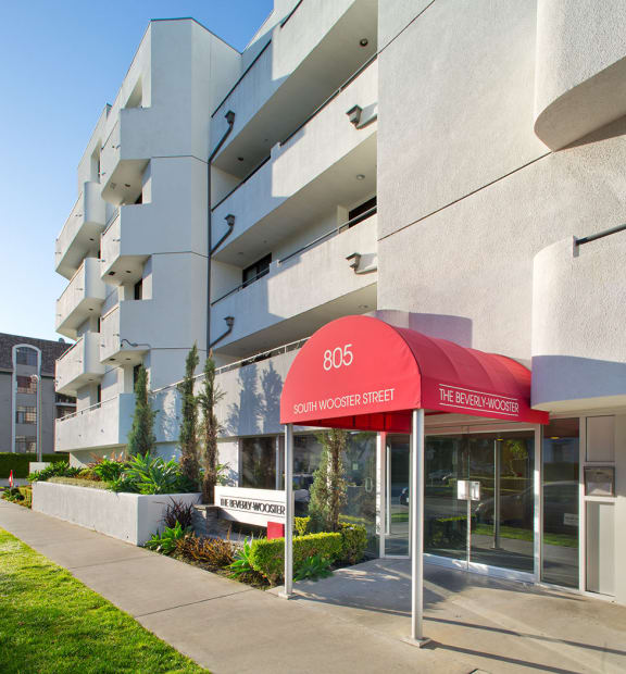 A white building with a red awning that says the address 805 Wooster..