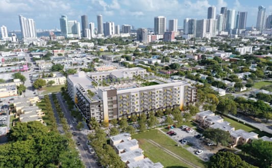 A modern apartment complex with balconies and a pedestrian walkway.