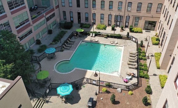 an aerial view of a swimming pool in front of a building