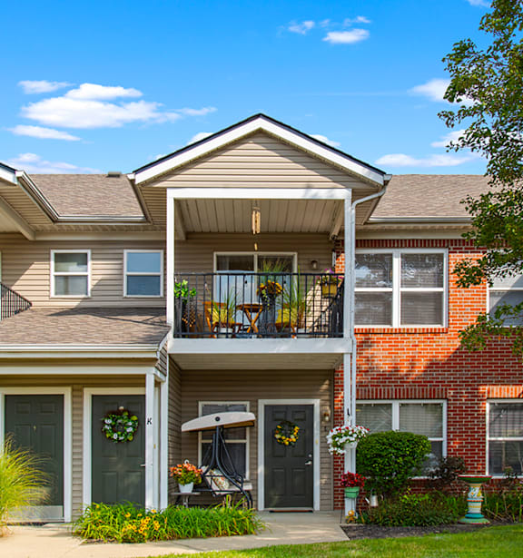 A row of townhouses with balconies and front yards.