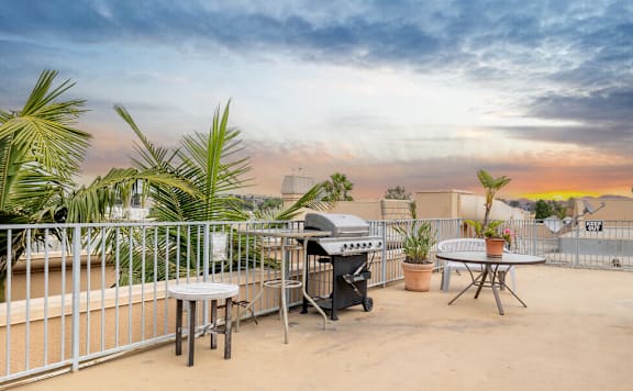 the patio has a bbq grill and a table and chairs