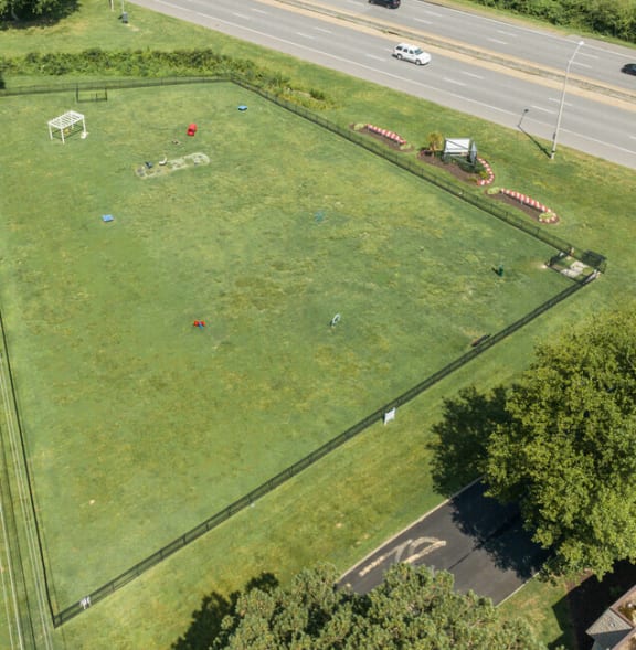an aerial view of a green field next to a highway at Bayville Apartments, Virginia