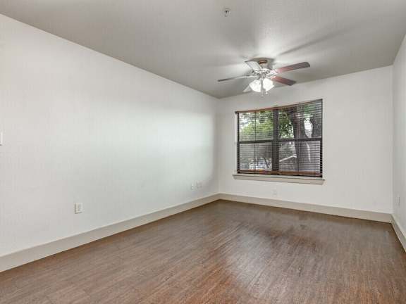 A room with a ceiling fan and a window with blinds. at Hickory Street Lofts Apartments, Denton, TX, 76201