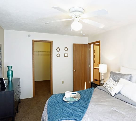 a bedroom with a large bed and a ceiling fan