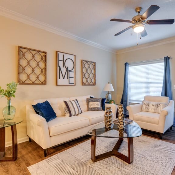 an open concept living room and dining area with a white dining table and rattan chairs at Magnolia Village Apartments, Jacksonville, FL, 32207