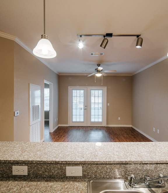 A kitchen with a sink and a ceiling fan.