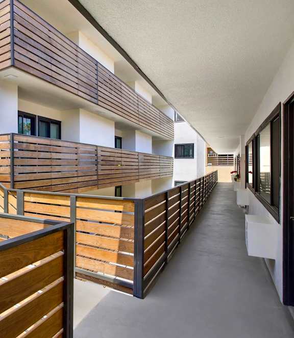 A long hallway with wooden railings and white walls.