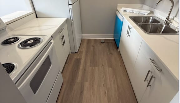 A kitchen with white cabinets and stainless steel appliances.