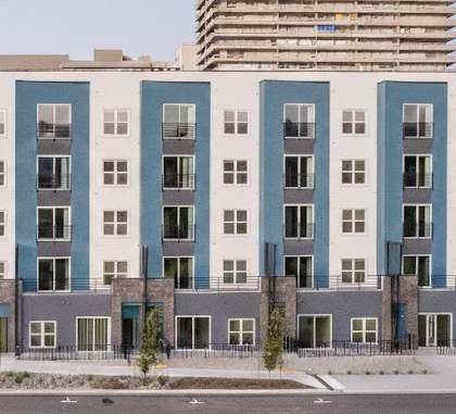 A modern apartment building with a mix of light and dark grey balconies.