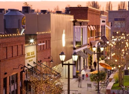 a city street at dusk with people walking down the street
