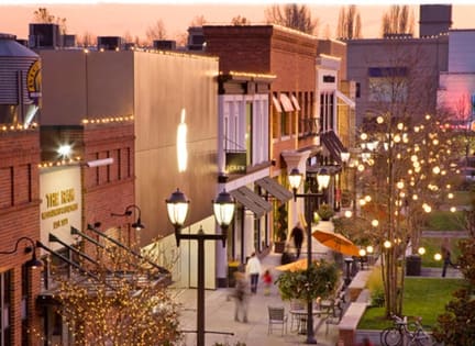 a city street at dusk with people walking down the street