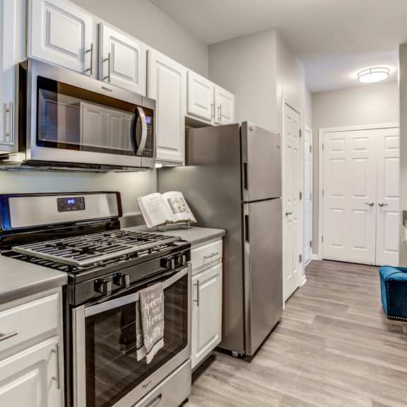 a kitchen with stainless steel appliances and white cabinets
