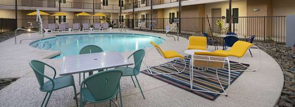 A pool area with a table and chairs.