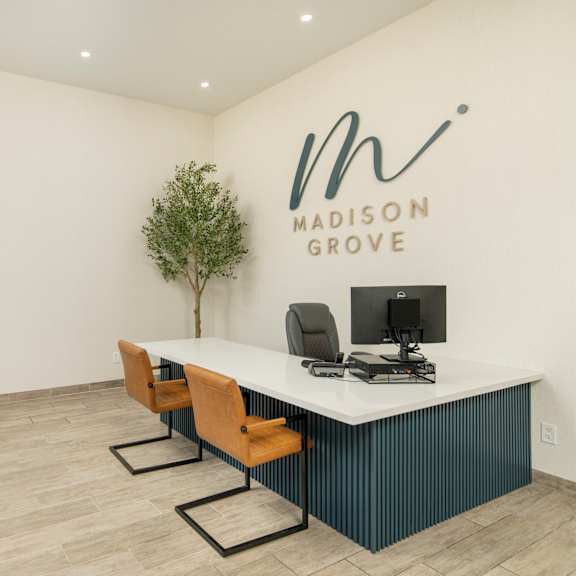 A Madison Grove office space with a desk, chairs, and a computer.