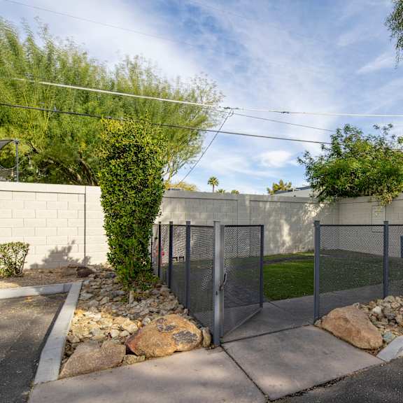 A white wall with a gate and a green sign on it.