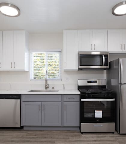 A kitchen with white cabinets and stainless steel appliances.
