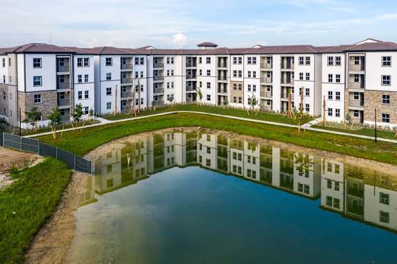 A large building with a pond in front of it.