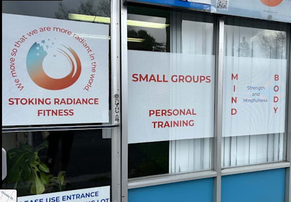 a sign in the window of a gym with small groups and personal training signs