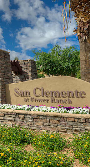 A sign that says San Clemente sits in front of a wall of flowers.