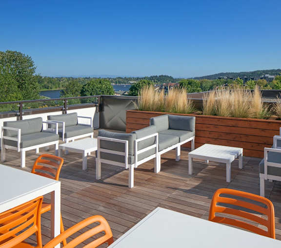 A patio with a white table and orange chairs.