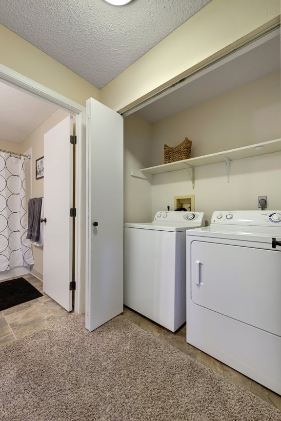 a laundry room with washer and dryer and a bathroom with a shower and  at Regency Woods, Minnetonka, Minnesota
