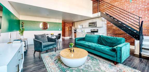 A living room with a green couch and a white coffee table.