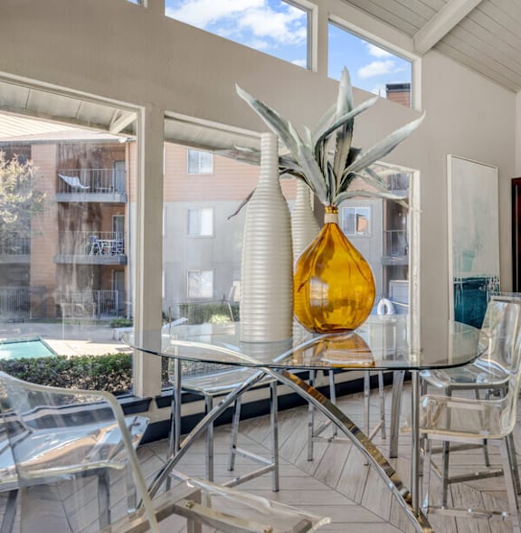 A dining room with a glass table and chairs.