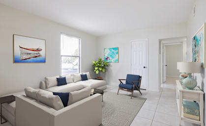 a living room with a white couch and a blue chair
