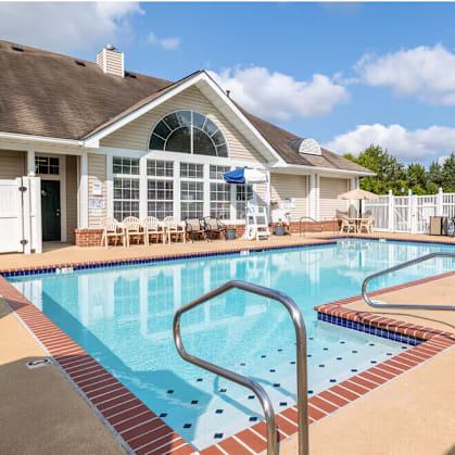 A swimming pool in a residential area with a house in the background.