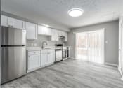 Thumbnail 2 of 13 - A kitchen with white cabinets and a stainless steel refrigerator.