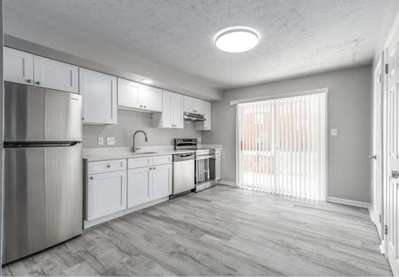 A kitchen with white cabinets and a stainless steel refrigerator.