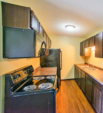 a kitchen with black appliances and wooden cabinets