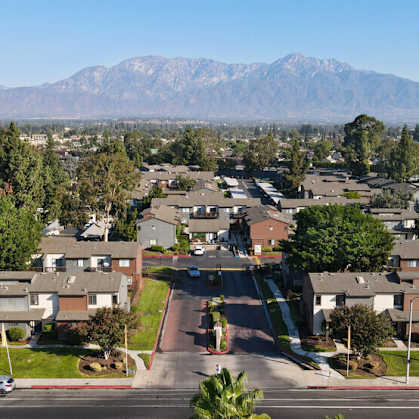 an aerial view of a neighborhood with houses and trees and mountains at Encore Apartments, Ontario, CA, 91764