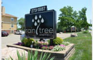 A sign for Rain Tree Apartments is displayed in front of a building. at Raintree Apartments, Topeka, 66614