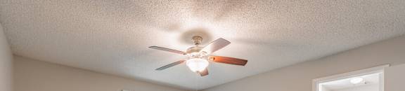 a bedroom with a ceiling fan and a door to a closet